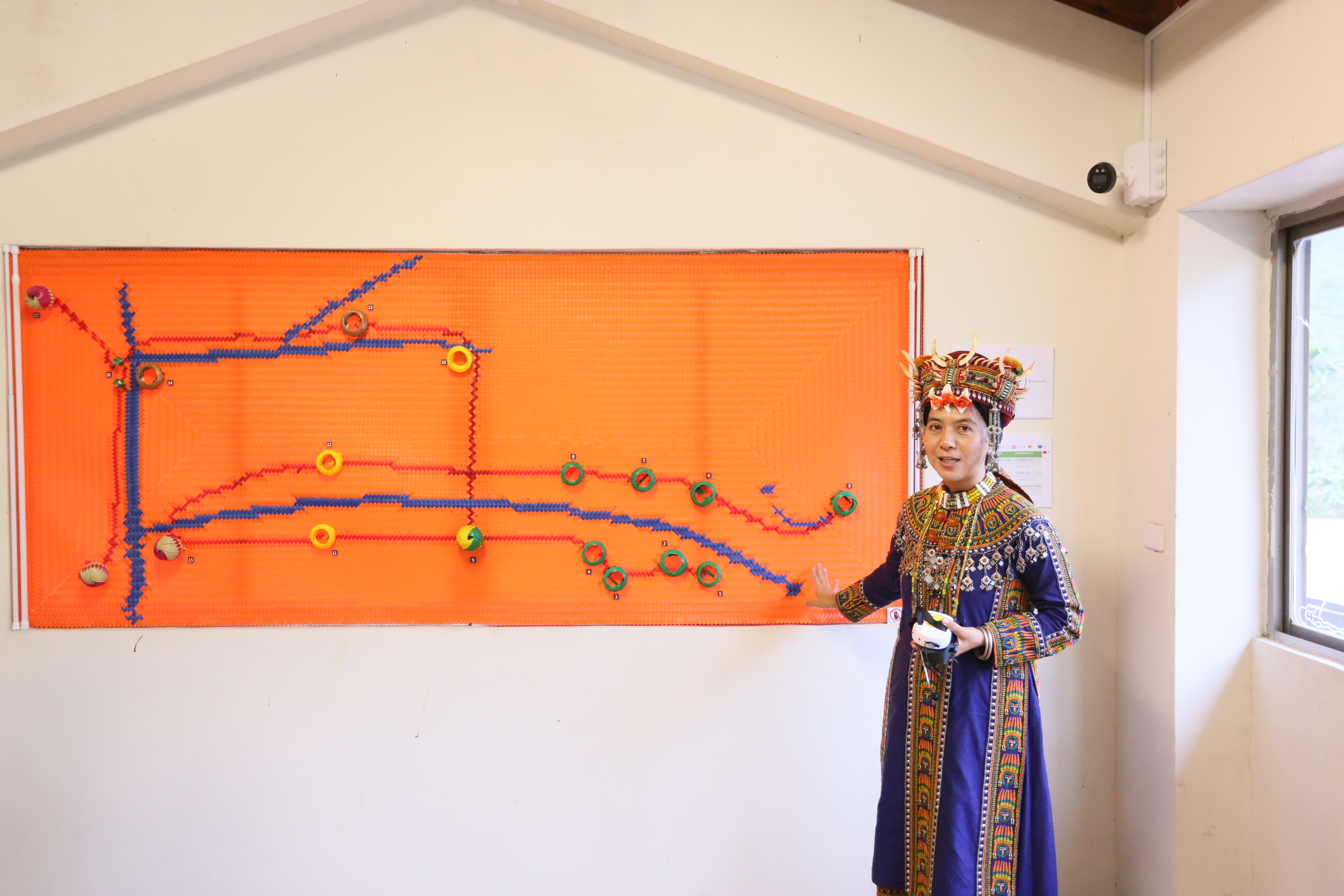 策展人貝若桑．甦給那笛米介紹族人用塑膠打包帶編織而成的「貿易之路」。