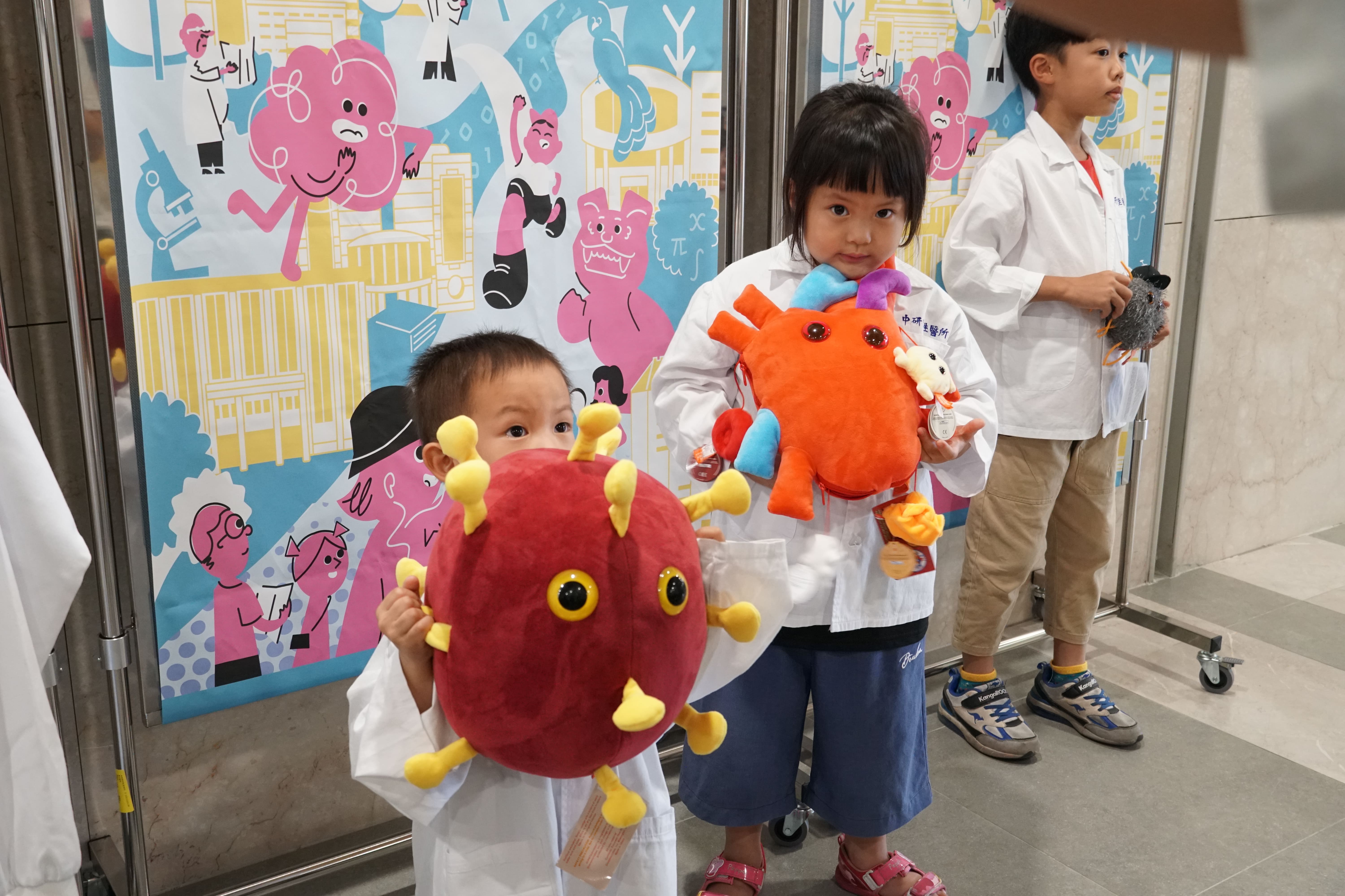 小朋友換裝實驗衣拍照。（圖片來源：中央研究院）