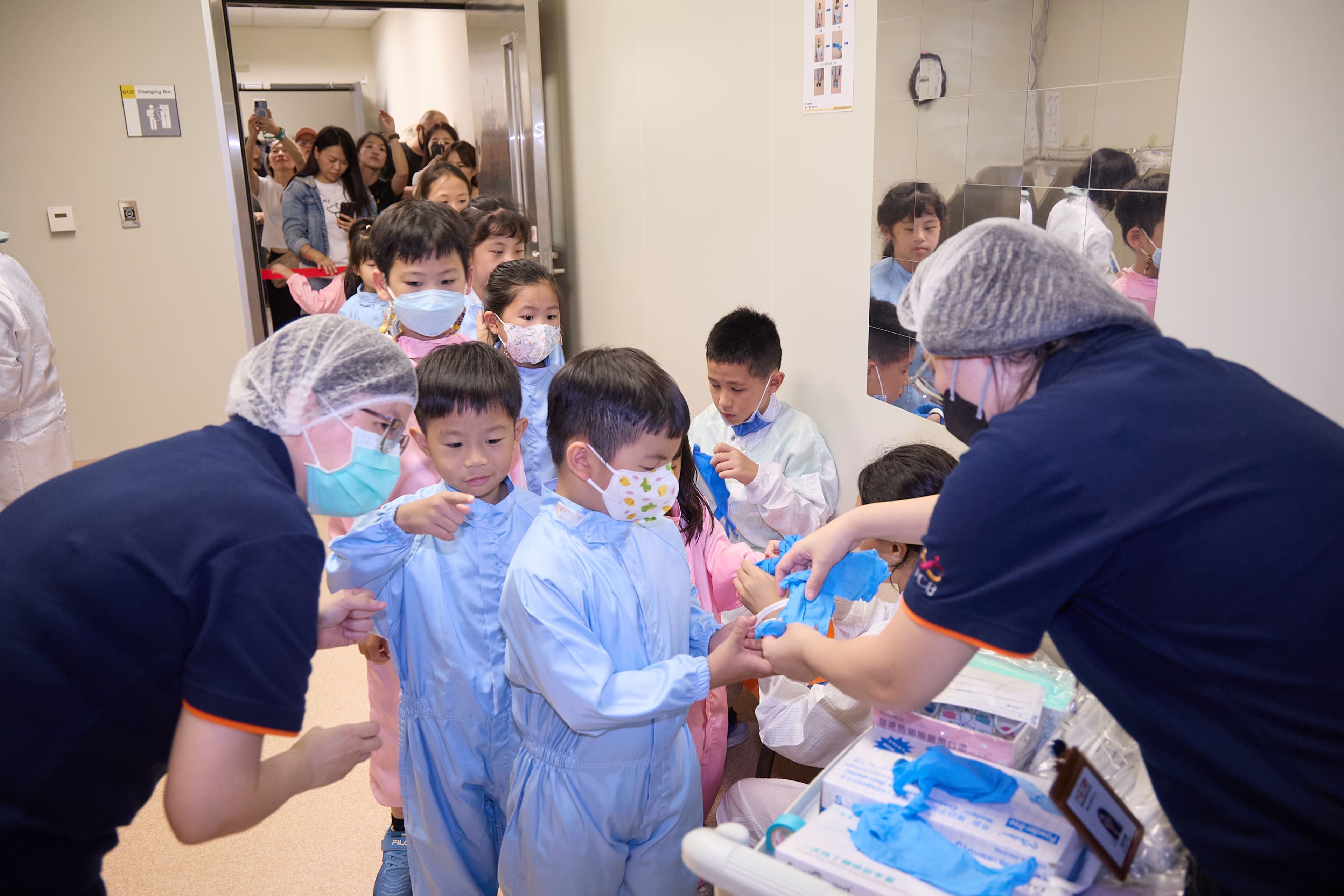 應科中心「無塵室穿梭與元件製程體驗」，了解如何正確穿脫無塵衣、鞋、髮帽、口罩及手套等裝備。（圖片來源：中央研究院）
