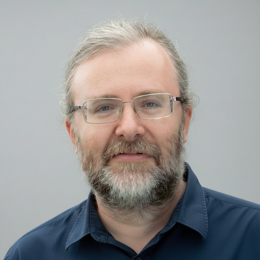 guy_cohen_head_shot_light_grey_background_blue_shirt